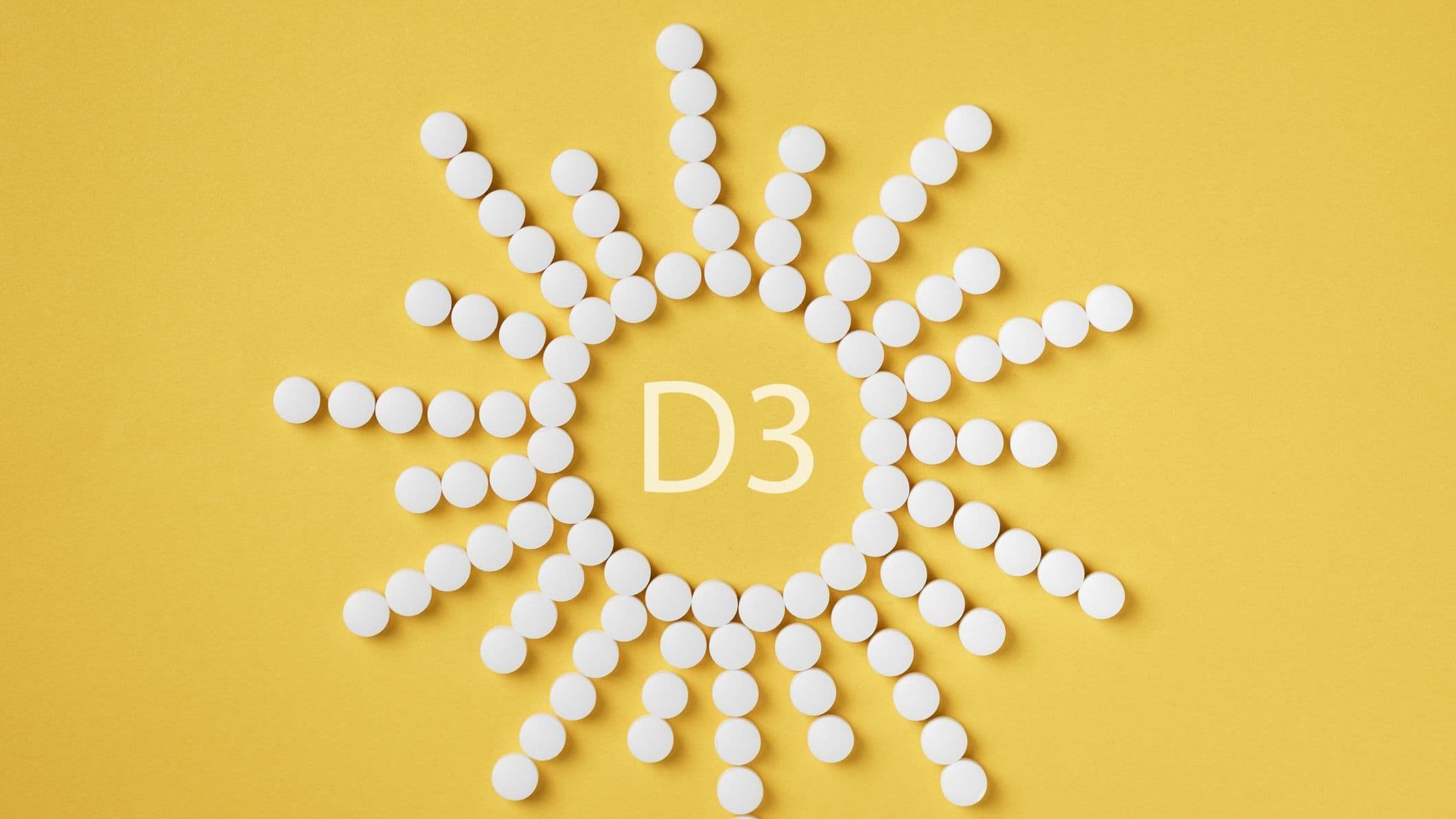 Vitamin D3 tabletter formade som en sol på gul bakgrund – symbol för solskensvitaminet D3