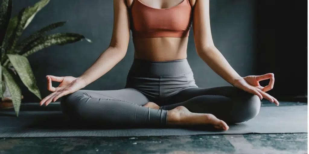 En kvinna sitter i en avslappnad yogaposition