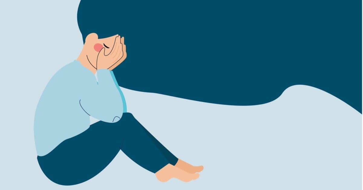 Sorgsen flicka som gråter med ansiktet i händerna