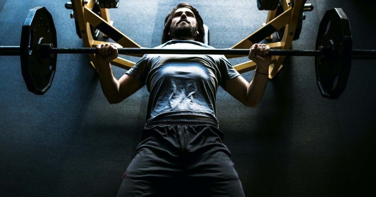Man lying on the floor doing bench press strength training