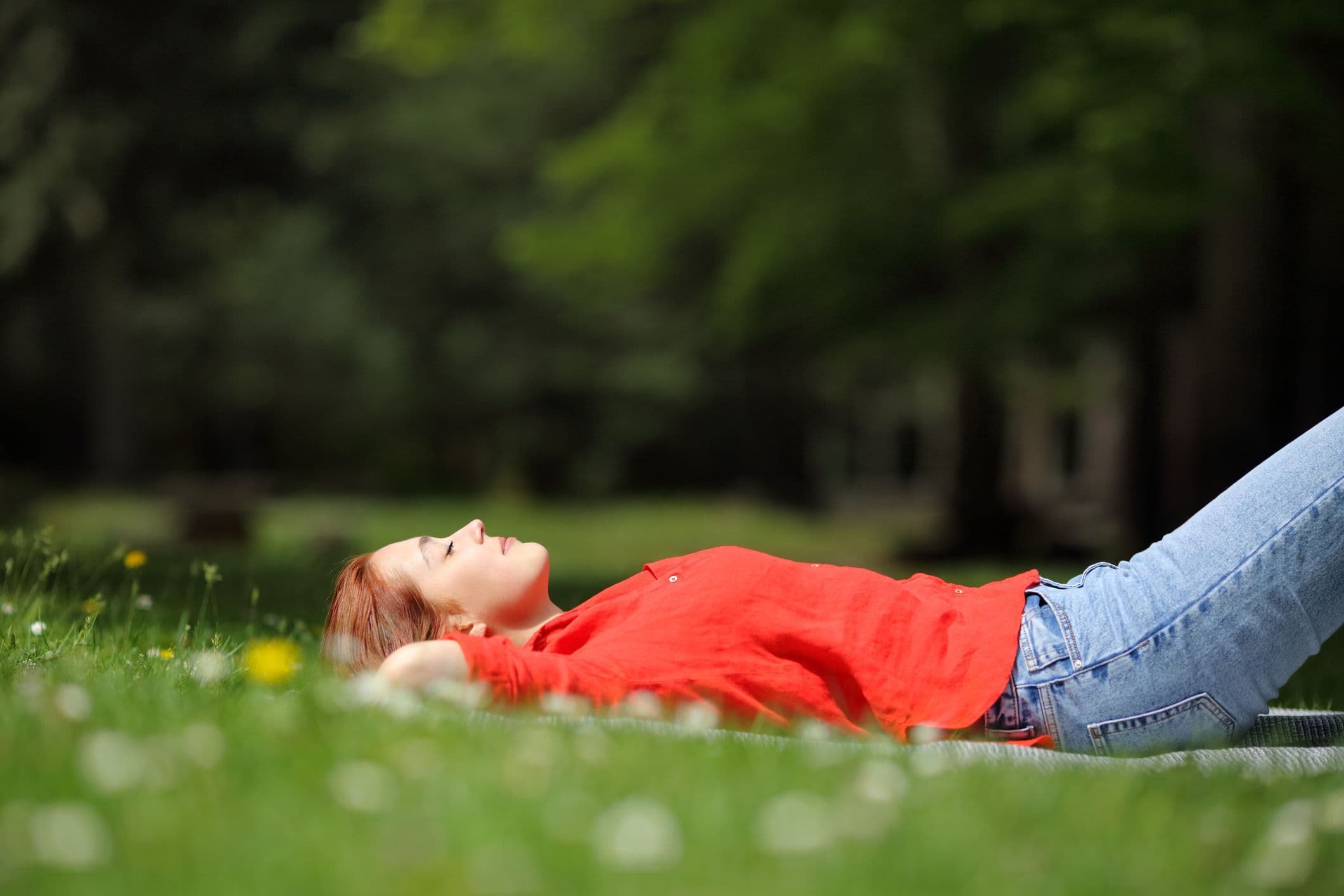 Tired woman resting in the grass in spring