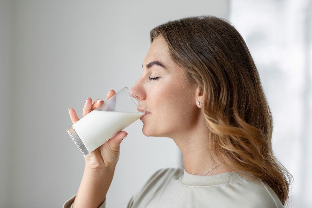 Kvinna som dricker ett glas mjölk och får i sig en god dos riboflavin