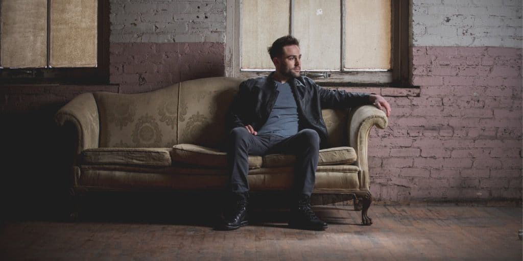 Depressed man sitting in a couch