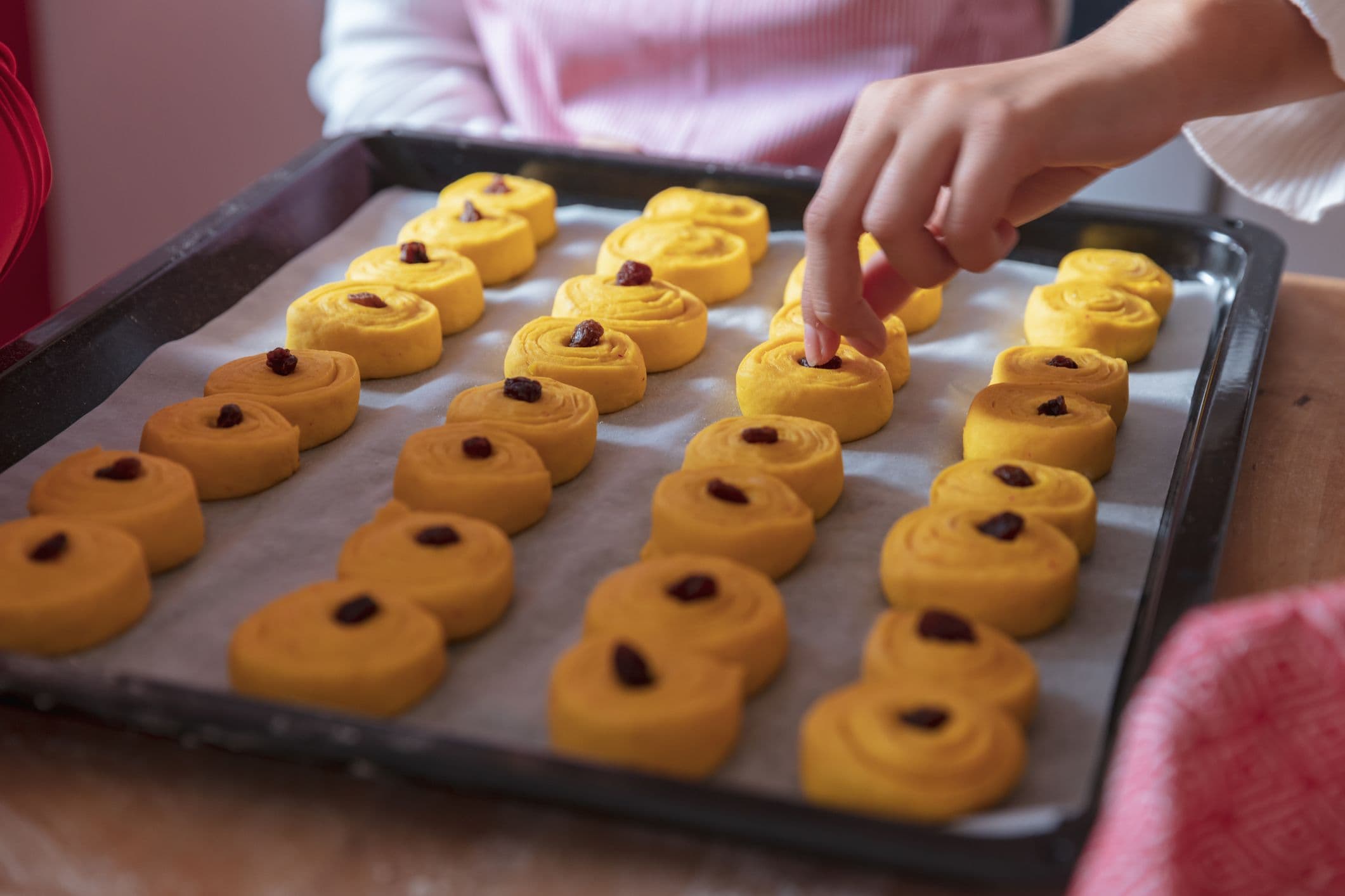 En kvinna som bakar lussekatter med saffran