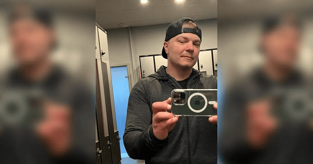 Ung mann tar bilde av seg selv i et speil i en gymgarderobe