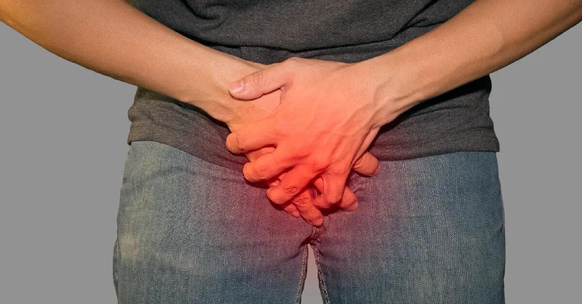 Mies, jolla on virtsaamisongelmia ja joka pitää käsiä haaroissansa