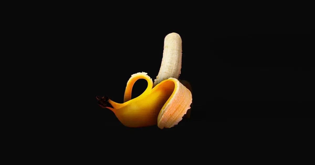 Upward pointing, half-peeled banana symbolizing an erect penis.