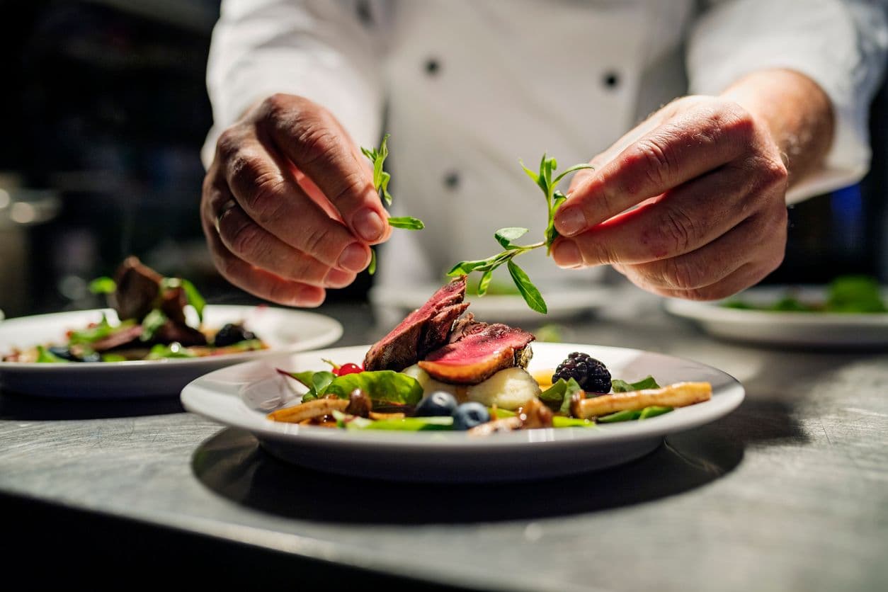 Gourmetkok som anretter en tallerken