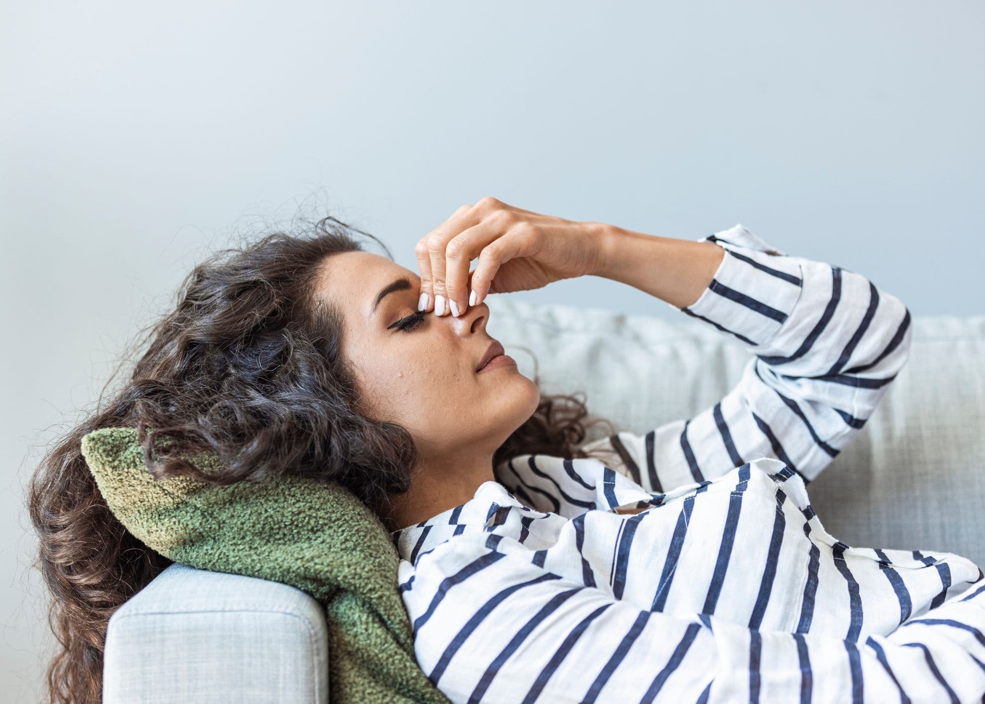 Väsynyt nainen makaa sohvalla