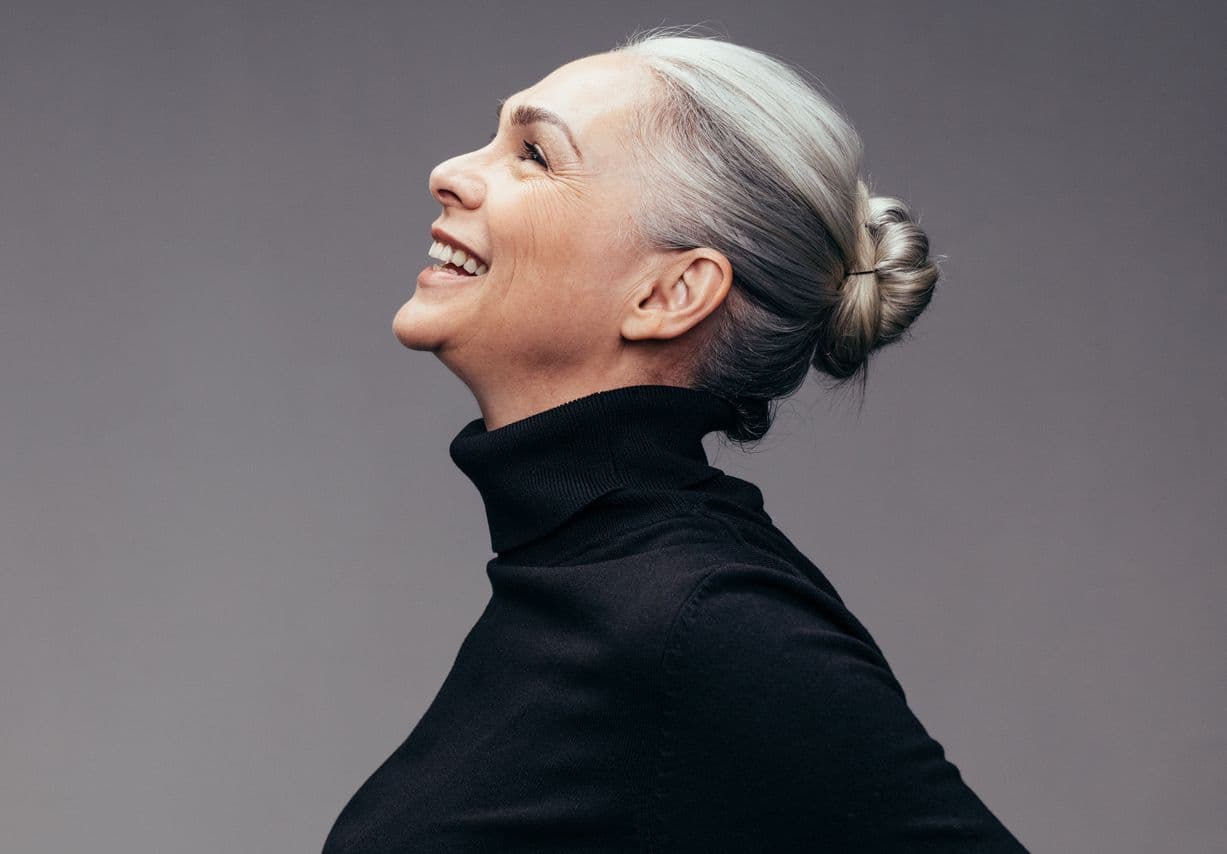 En glad kvinde med gråt hår i en elegant knold