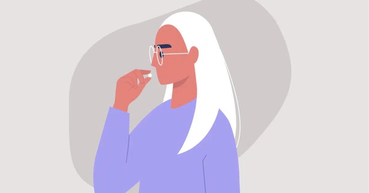 Nainen ottamassa vitamiinia tai ravintolisää